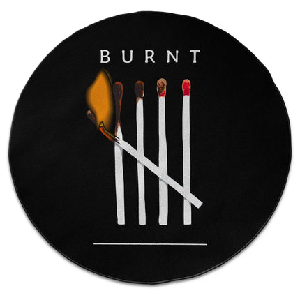 Burnt matches graphic round rug with Jet Black edge finish shown from above on white background