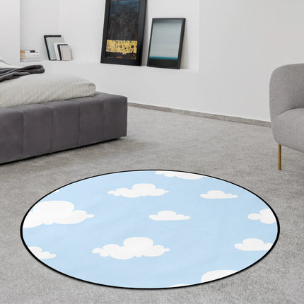 Cloud nine graphic round rug with white cartoon clouds across a light blue sky background styled in a modern bedroom with Jet Black edge finish