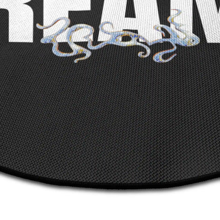 Close up of concrete dreams graphic round rug with oversized typography showing Jet Black edge and woven polyester texture