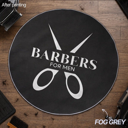 Overhead view of a round fog grey custom rug with a black-and-white 'Barbers for Men' scissors logo design, placed on a wood floor in a barbershop setting.