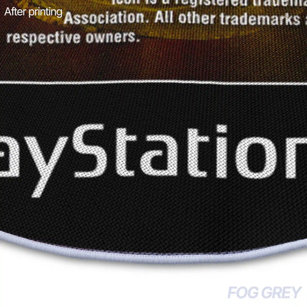 Close-up of a rug edge showing printed disc label text and the white piped border against a fog grey background.