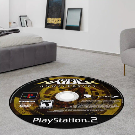 Round rug printed to look like a PlayStation 2 game disc labeled 'Tomb Raider Anniversary,' displayed on a grey carpet in a living room.