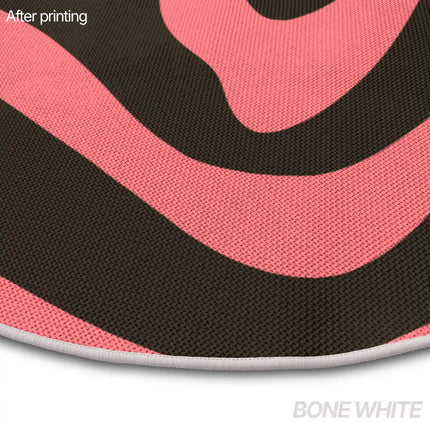 Close-up of a bone white piped rug edge showing a pink and black wavy stripe pattern print.
