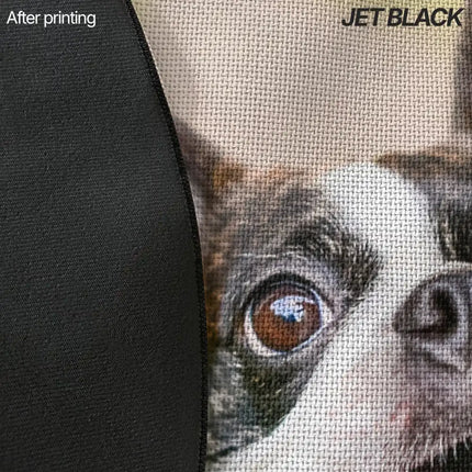 Close-up of a jet black rug edge showing plain black fabric next to a printed close-up photo of a dog's eye and fur.