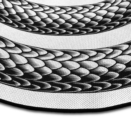 Close up of Endless Coil graphic round rug with serpent spiral artwork showing Jet Black edge and woven polyester texture