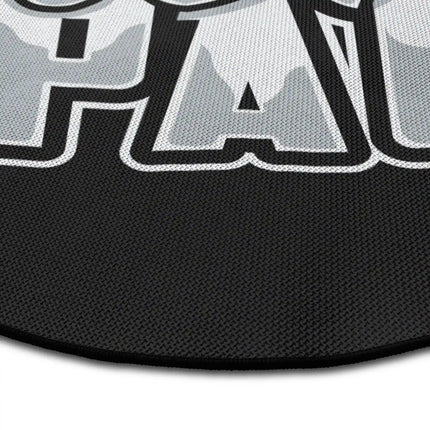 Close up of black typography round rug with “Give Me More Space” text showing Jet Black edge and woven polyester texture