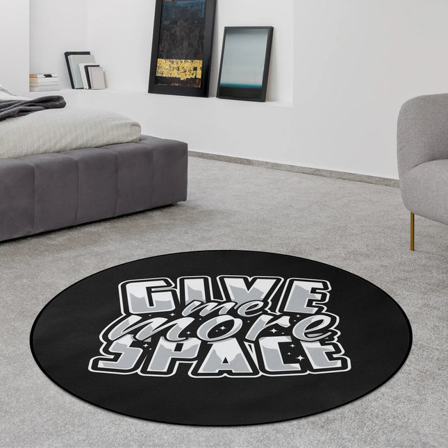 Black typography graphic round rug with “Give Me More Space” text styled in a modern bedroom with Jet Black edge