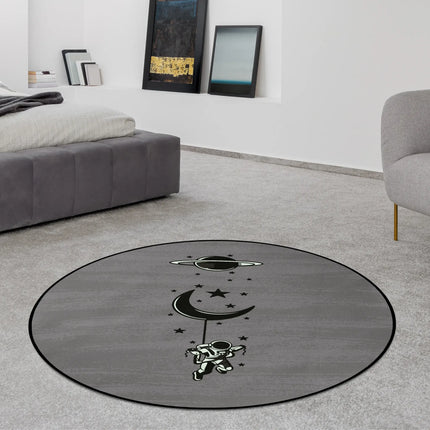 Lost in orbit graphic round rug with floating astronaut beneath crescent moon and stars styled in a modern bedroom with Jet Black edge finish