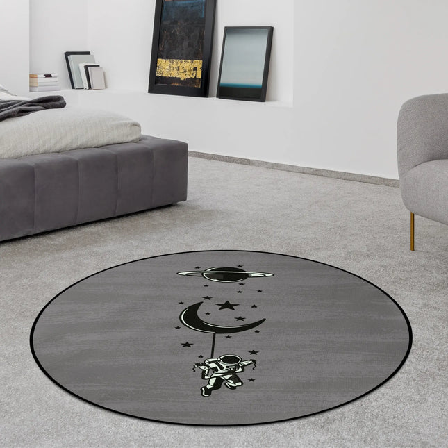 Lost in orbit graphic round rug with floating astronaut beneath crescent moon and stars styled in a modern bedroom with Jet Black edge finish