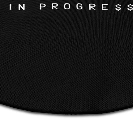 Close up of millionaire in progress graphic round rug Jet Black edge showing woven polyester detail