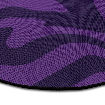 Close up of purple haze round rug with flowing abstract wave artwork showing Jet Black edge and woven polyester texture