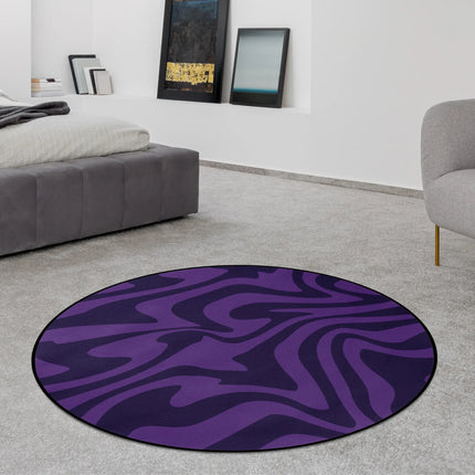 Purple haze round rug with flowing abstract wave pattern in deep violet tones styled in a modern bedroom with Jet Black edge finish