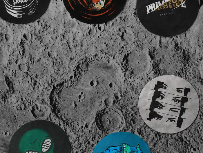 Seven modern round designer rugs displayed on a realistic moon surface with natural shadows, featuring astronaut, cartoon, abstract, alien, eyes, zodiac fish, and minimalist graphic designs