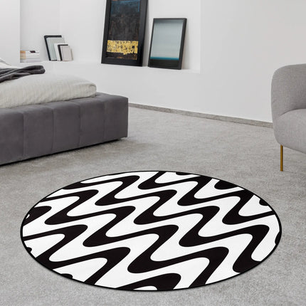 Static flow graphic round rug with bold black and white wave pattern styled in a modern bedroom with Jet Black edge finish