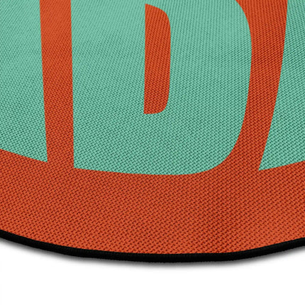 Close up of sunset good vibes round rug with retro typography artwork showing Jet Black edge and woven polyester texture