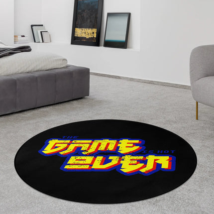 Black retro gaming graphic round rug with “The Game Is Not Over” text in bold yellow and blue lettering styled in a modern bedroom with Jet Black edge finish