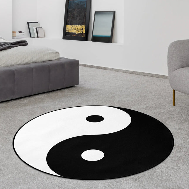 Yin yang graphic round rug with bold black and white balance symbol styled in a modern bedroom with Jet Black edge finish
